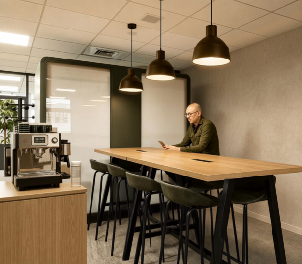 Área de trabalho com mesa coletiva e estação de café